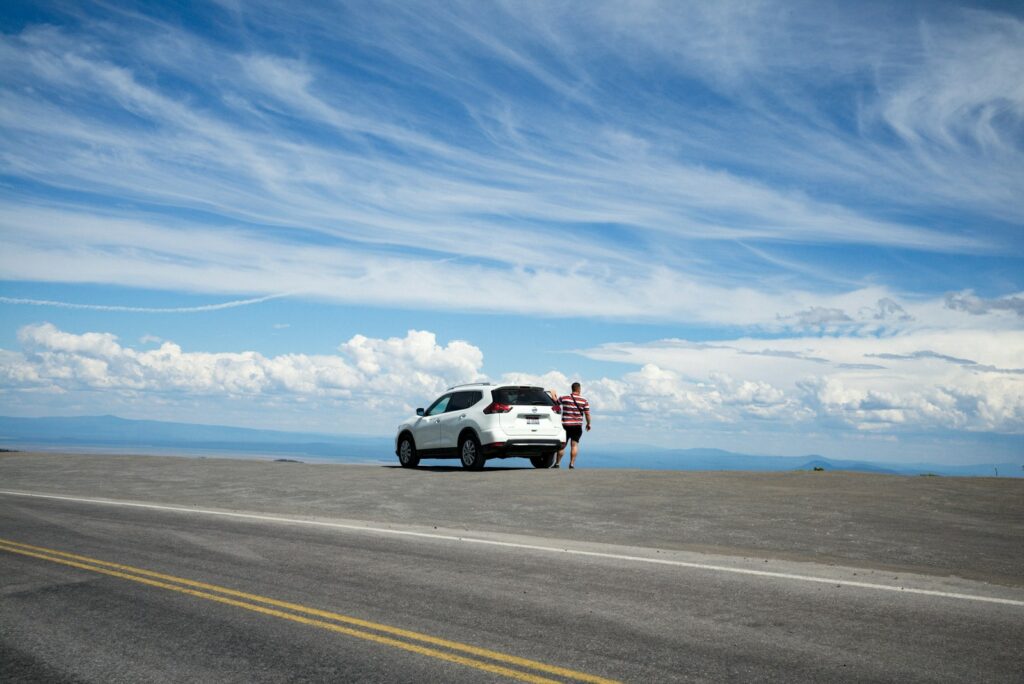 White SUV on a road trip under a blue sky